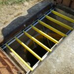 Ouverture rectangulaire en béton sécurisée par des barreaux antichute PRV jaunes