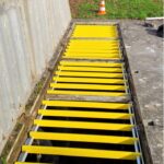 Barreaux antichute PRV jaunes sur un accès extérieur en béton
