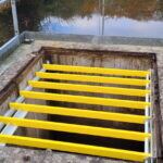 Ouverture rectangulaire équipée de barreaux antichute PRV jaunes au-dessus de l'eau