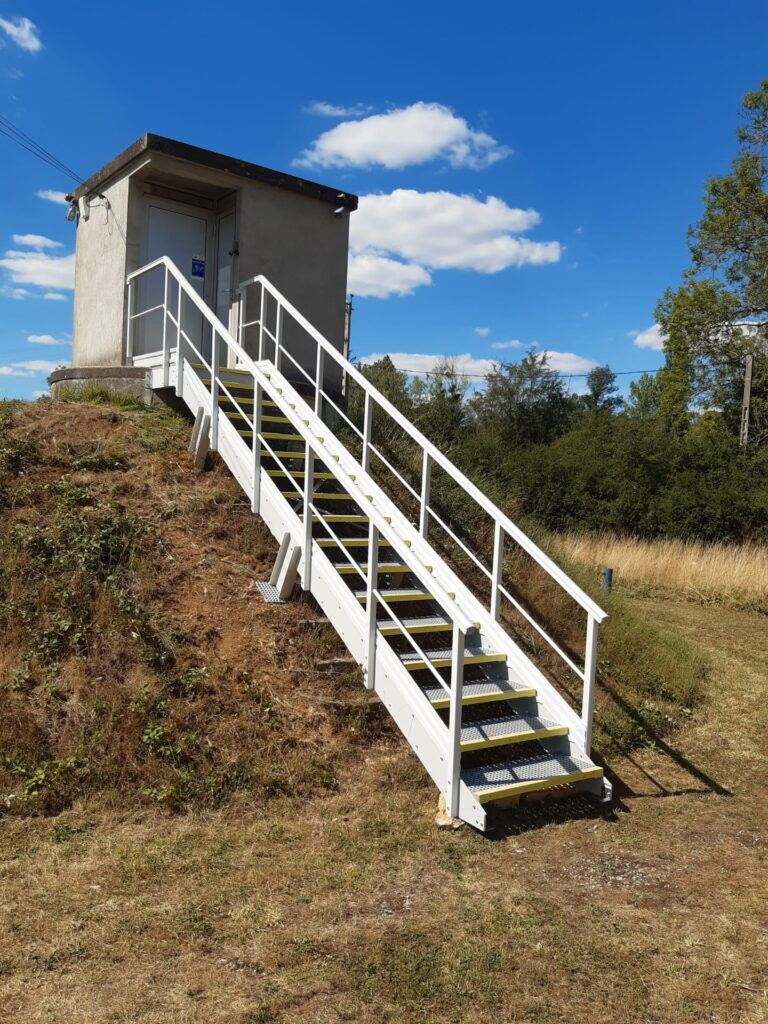 Escalier PRV avec garde-corps menant à un poste technique en extérieur