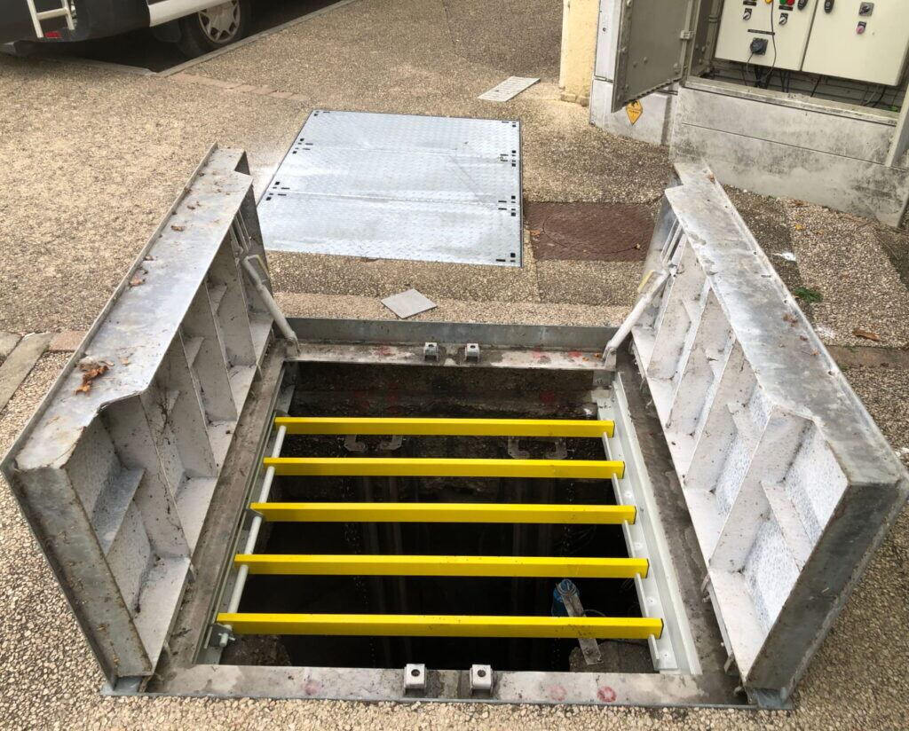 Regard ouvert sécurisé par des barreaux antichute PRV jaunes, capot relevé