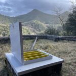 Trappe PRV blanche ouverte en extérieur, barreaux antichute jaunes, paysage de montagne